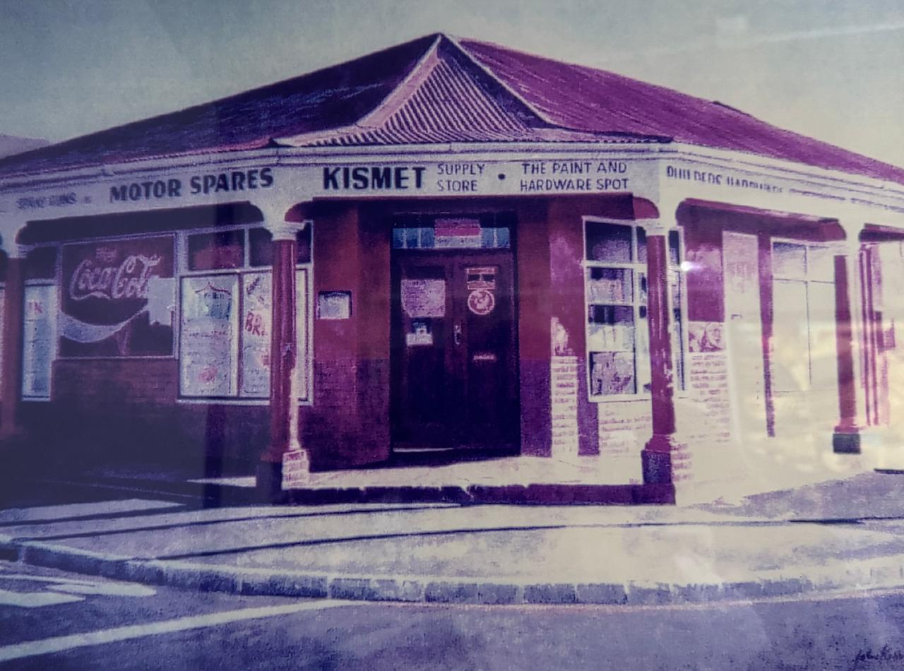 Vintage photograph of Kismet Supply Store — Motor Spares, Supply Store, and The Paint and Hardware Spot signage